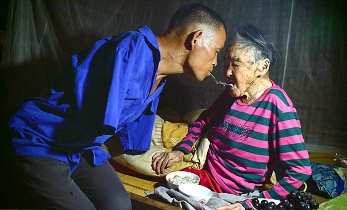 This Man With No Arms Spoon Feeds His Paralyzed Mother Using His Teeth