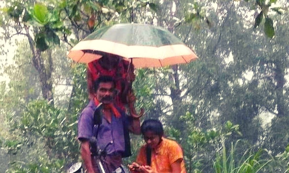 A Fathers Love: Man Holds Umbrella Over Daughter As She Attends Online Classes Amid Rain