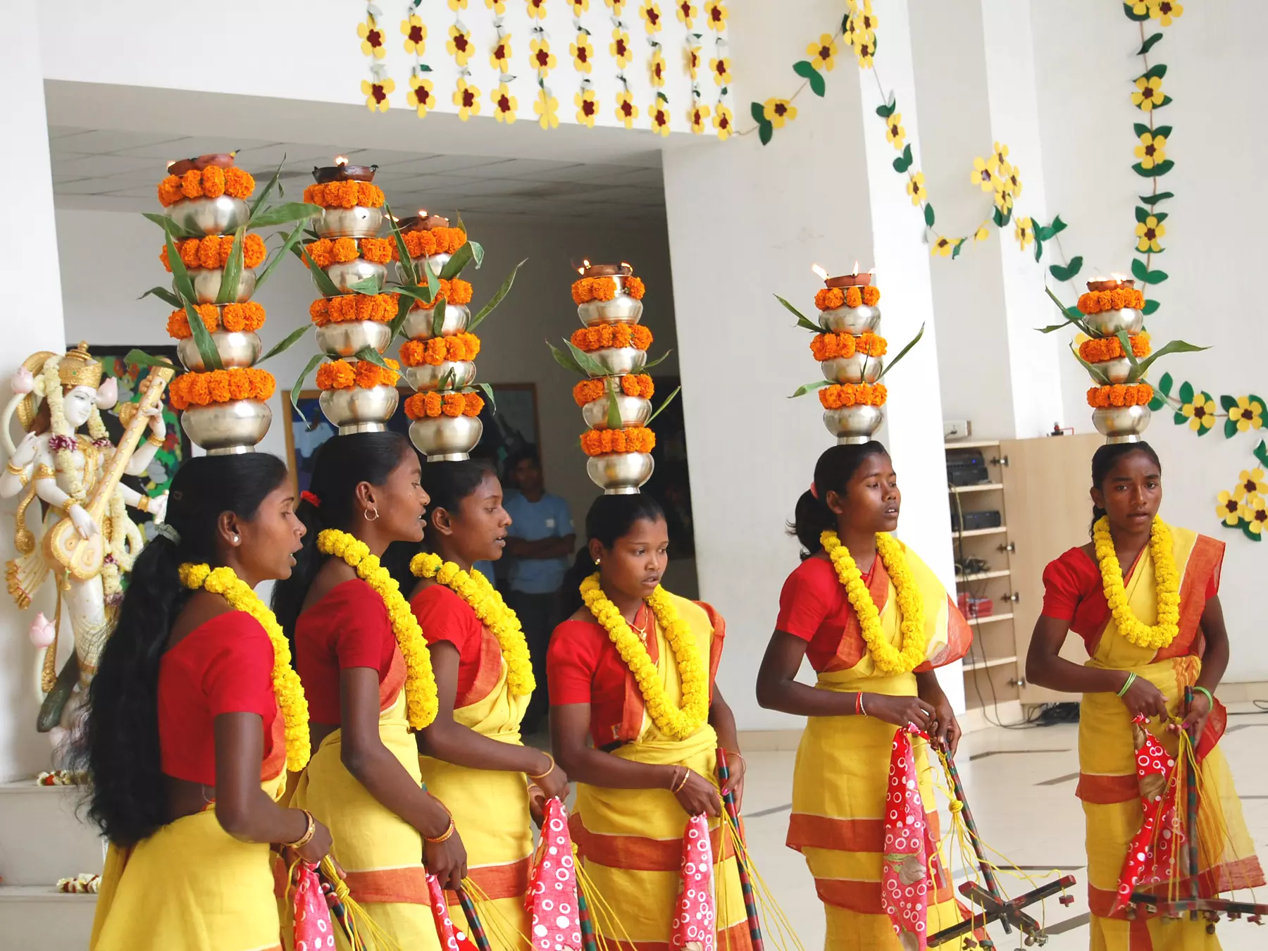 A cluster of students showcasing a cultural and traditional performance within the school grounds.  
