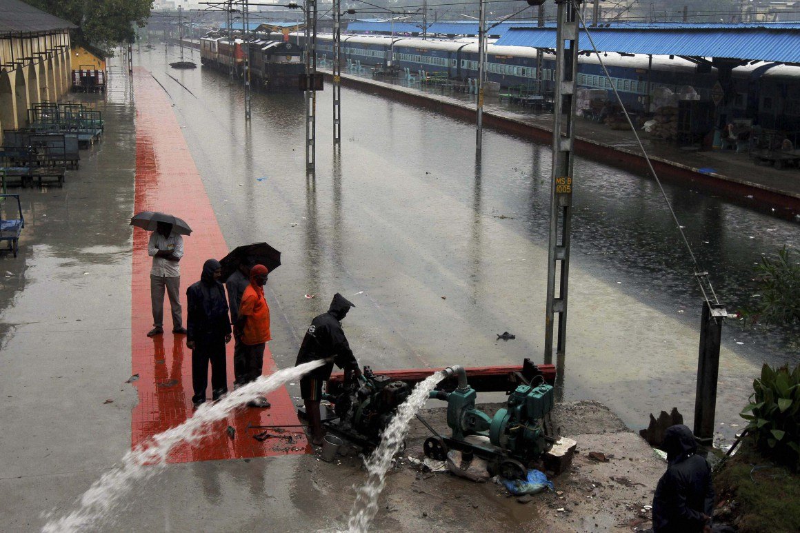 Chennai: Indian Railway workers pumping out the rainwater from tracks at inundated Vyasarpadi railway station after heavy rains in Chennai on Friday. PTI Photo (PTI11_13_2015_000280B)