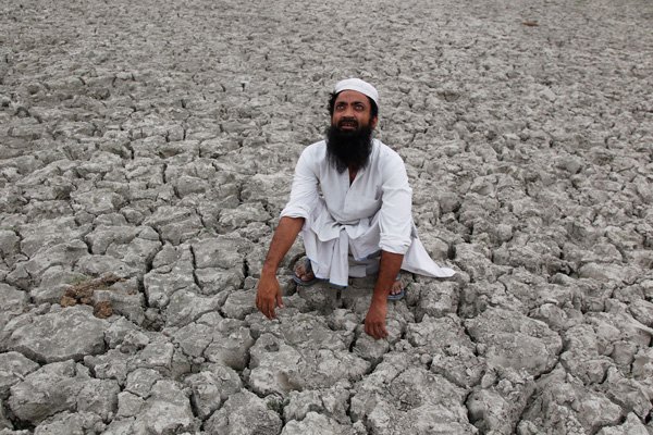 ALLAHABAD, INDIA - 2015/06/04: A farmer at cracked land looking to the sky hoping for monsoon rain on a hot summer in Allahabad. (Photo by Ravi Prakash/Pacific Press/LightRocket via Getty Images)