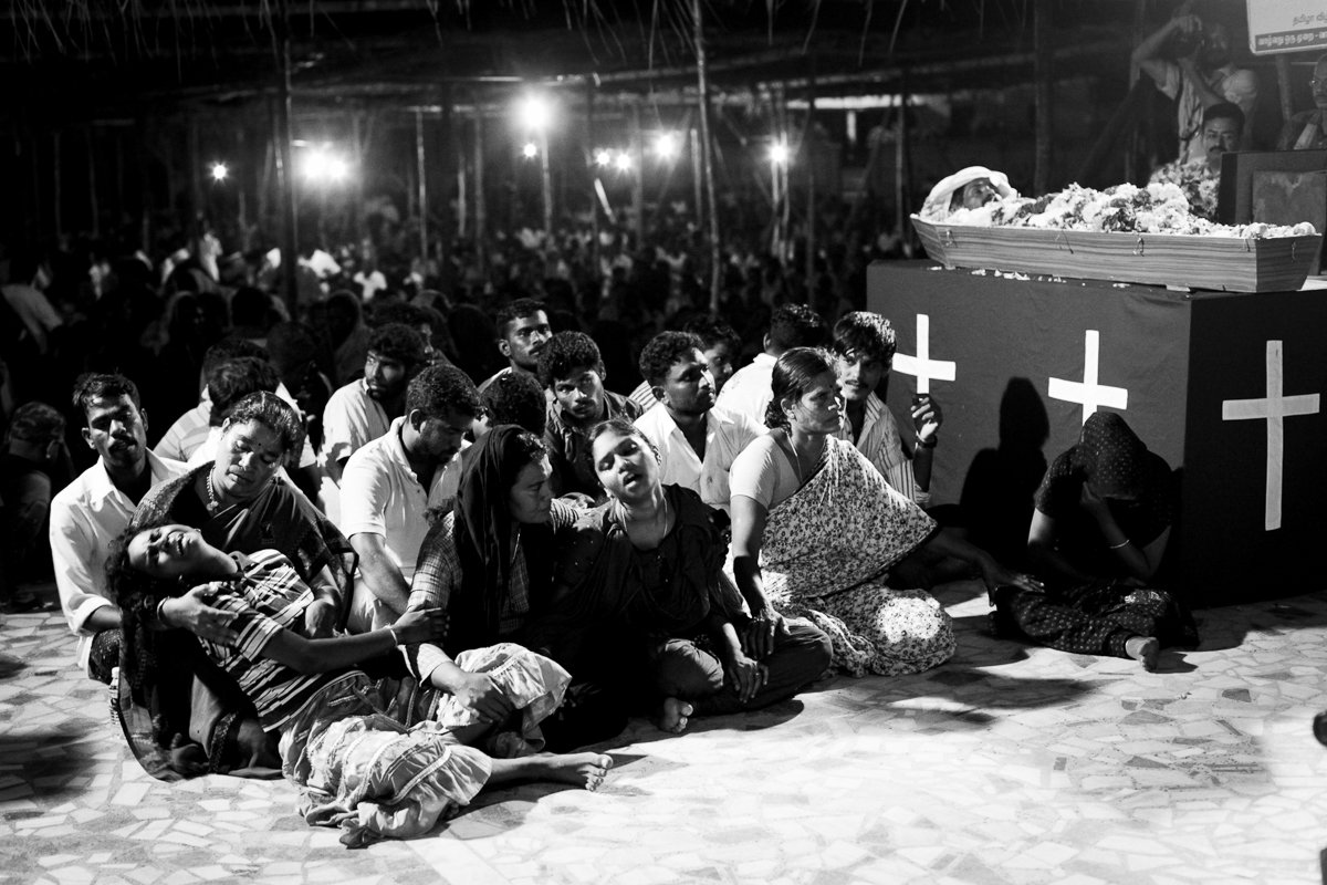 Children of Sahayam cry during his funeral mass. He fell off a boulder he was standing on inside the waters due to fear when the coast guard aeroplane flew very low and was killed by the impact. September 17, 2012.